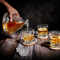 Triangle decanter pouring whiskey into a rocks glass